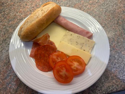 a plate of food with sausage tomatoes and cheese at Braeburn Guesthouse in Fort William