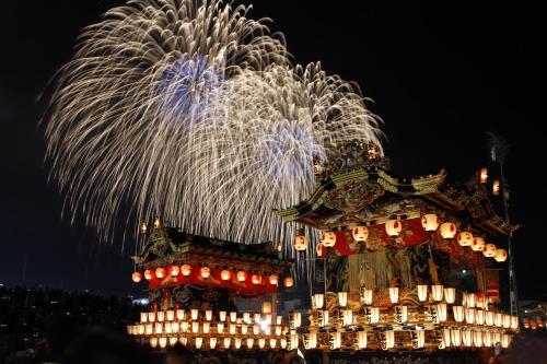 a firework display behind a building with fireworks in the background at 子どもが主役の貸切宿 Villa Brave in Chichibu