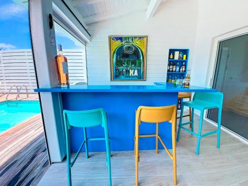 a bar with two chairs and a blue counter at Villa Marguerite private pool and hot tub in Orient Bay in Orient Bay