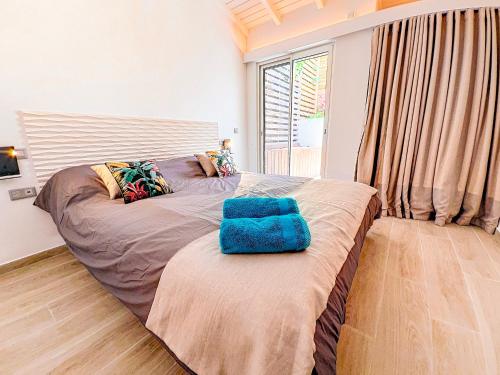 a bedroom with a large bed with a blue chair on it at Villa Marguerite private pool and hot tub in Orient Bay in Orient Bay