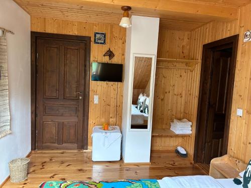 Zimmer mit einem Bett und einer Holzwand in der Unterkunft Casa Muchia lui Gîrniță in Braşov
