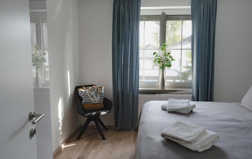 um quarto com uma cama, uma cadeira e uma janela em KRACHER Guesthouse No 3 em Illmitz