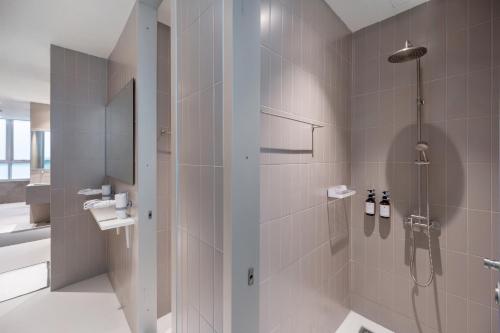 a bathroom with a shower and a sink at Nidhra Boutique in Bangkok