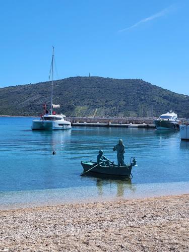 two people in a small boat in the water at Apartment TRI MASLINE with seaview in Trogir