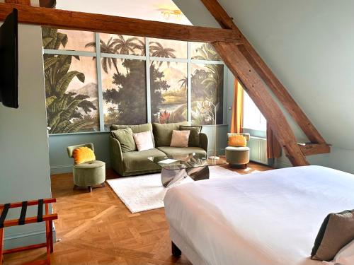 une chambre avec un lit et un canapé dans une pièce dans l'établissement La Villa Ribière, à Auxerre
