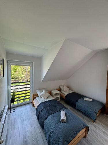 een slaapkamer met twee bedden en een groot raam bij Apartamenty ZATOR20 2 min od Energylandii in Zator