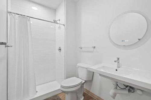 a white bathroom with a toilet and a sink at Town St Medical Lofts in Columbus