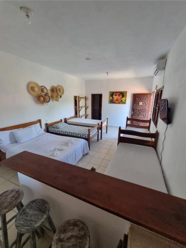 a hotel room with two beds and two chairs at Pousada Lua de Jeri in Jericoacoara
