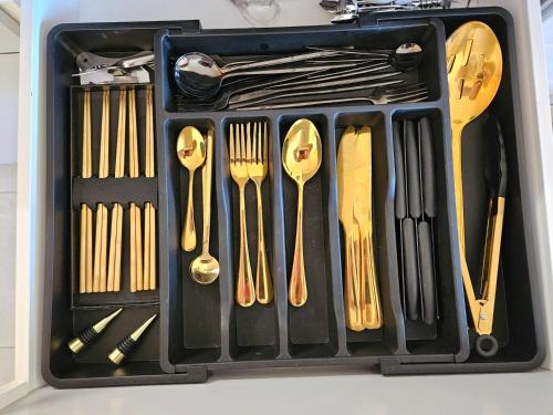 un récipient en plastique rempli d'ustensiles, de fourchettes et de cuillères dans l'établissement Presqu'ile de Giens, Maison Rdc avec Accès et Jardin Privés sans Vis-à-vis, Piscine, Plages à 2 min à pieds, à Hyères