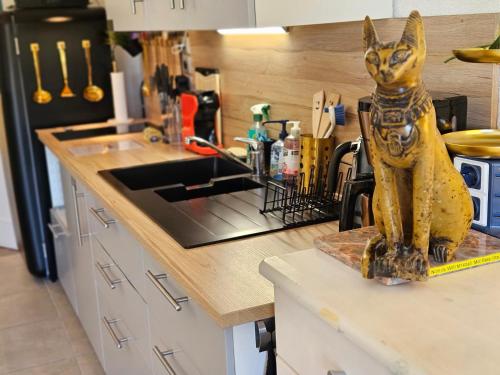 una estatua de un gato sentado en un mostrador en una cocina en Presqu'île de Giens, Var, La Vue sur le Paradis, Maisonnette 5p av Accès et Jardin PRIVES, Piscine, Plages à 2 min, Face à Porquerolles, en Hyères
