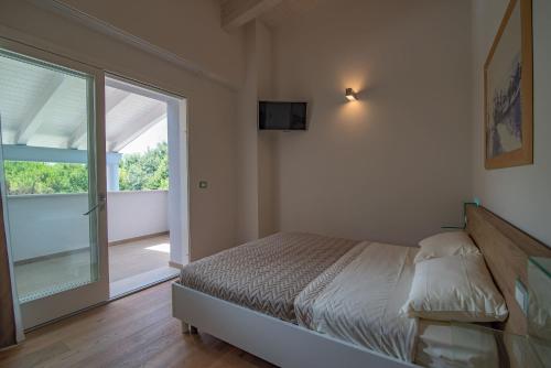 een slaapkamer met een bed en een glazen schuifdeur bij Borgo del Faro in Fano