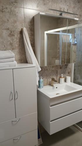 スコシャンにあるApartments Sanの洗面台と鏡のある白いバスルーム