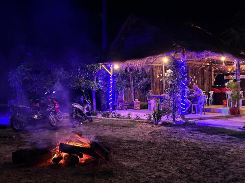 a fire in front of a house with blue lights at Maloop Cafe Bungalow in Koh Rong Island