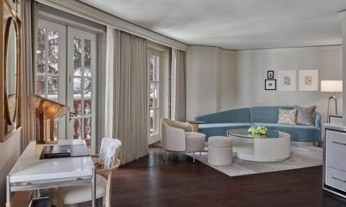 a living room with a blue couch and a table at St. Regis Aspen Resort in Aspen