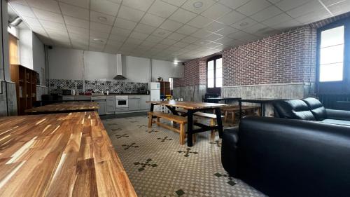 une grande chambre avec une table et une cuisine dans l'établissement Albergue La Estación, à Llanes
