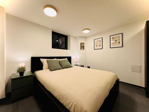 1 dormitorio con 1 cama grande y 2 lámparas. en Aqua Aura - Deluxe Spa Getaway with Sauna & Pool, en Stegen