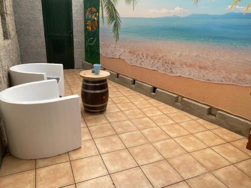 a patio with two chairs and a table on the beach at BYP in Ribadumia