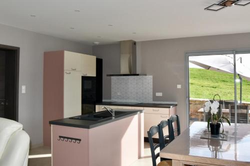 une cuisine avec un évier et une table avec des chaises dans l'établissement Charmant gîte, au calme, avec vue imprenable sur la nature environnante, à Deycimont