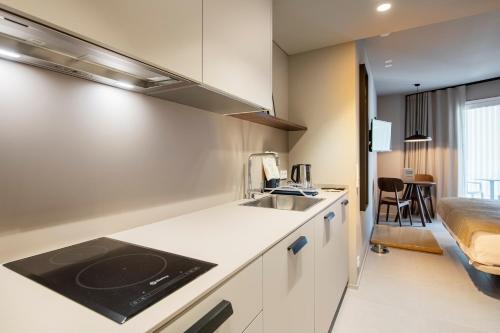 a kitchen with a sink and a bed in a room at APARTAMENTS LA CARPA in Banyoles