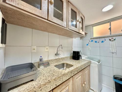 a kitchen with a sink and a washing machine at Palm Beach | Porto das Dunas - CE in Mangabeira