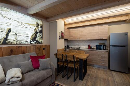 a living room with a couch and a kitchen at Chalet Da Florin in Livigno