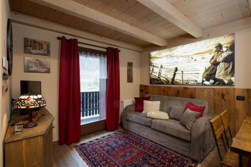 sala de estar con sofá y ventana en Chalet Da Florin, en Livigno