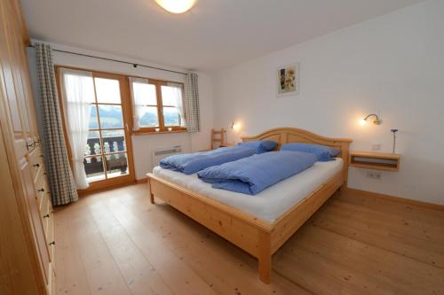 豪斯哈姆的住宿－Summererhof Hausham，一间卧室配有一张带蓝色枕头的床。