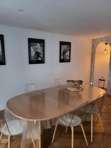a dining room with a wooden table and chairs at Bel appartement avec Balnéo in Sainte-Marie-aux-Mines