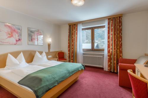 a hotel room with a bed and a window at BSW Hotel Hubertus-Park in Schönau am Königssee