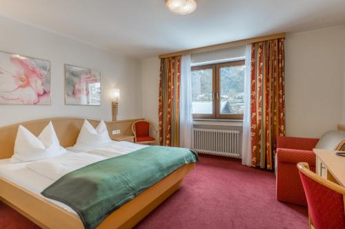 Una habitación de hotel con una cama y una ventana. en BSW Hotel Hubertus-Park, en Schönau am Königssee