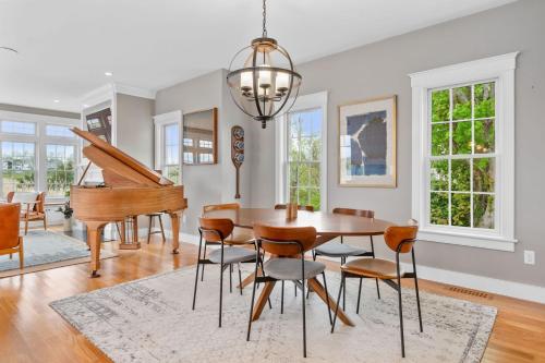 a dining room with a table and a piano at 19 State Street Sandwich - Marsh Mellow in Sandwich