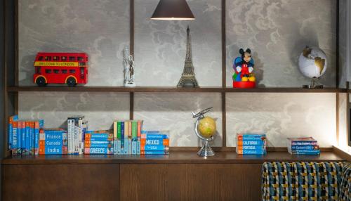 a shelf with books and a red double decker bus at ibis Styles London Gatwick Airport in Crawley