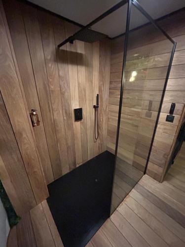 une douche avec une porte vitrée dans une pièce dans l'établissement La Tropicale Dieppe, à Dieppe
