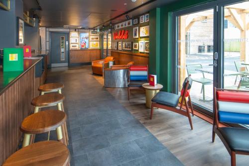 a restaurant with chairs and tables and a bar at ibis Styles London Gatwick Airport in Crawley
