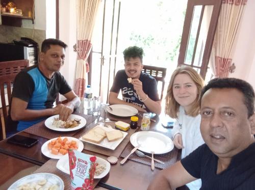 a group of people sitting around a table eating food at Vino Villa Tourists & Local Accommodations - 24 Hrs in Kandy