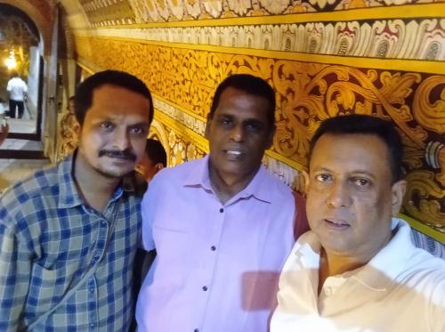 three men posing for a picture in front of a building at Vino Villa Tourists & Local Accommodations - 24 Hrs in Kandy