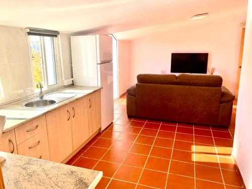 uma cozinha com um sofá no meio de um quarto em Hostal Sango Sierra de las Nieves em Alozaina