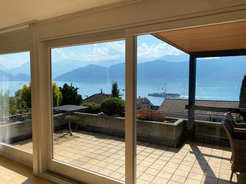 a view of the ocean from a room with sliding glass doors at Swiss Paradise Weggis in Weggis