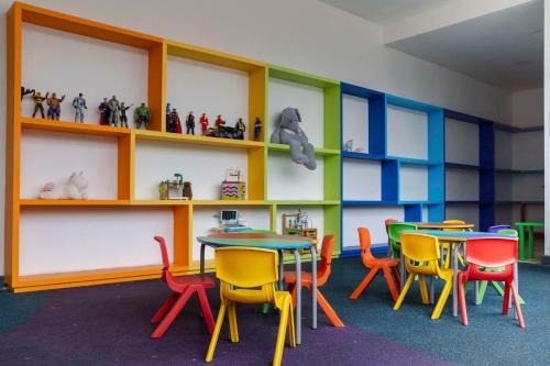 a classroom with colorful chairs and tables and shelves at New Chic Condo with Gym Access & Private Roof in Mexico City
