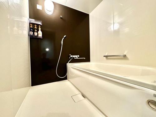 a bathroom with a bath tub and a shower at Resort Stay Spa Tsurumi in Beppu
