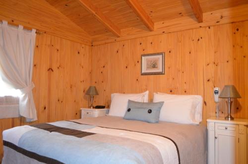 a bedroom with a large bed with wooden walls at Santa Monica Aparts in El Calafate