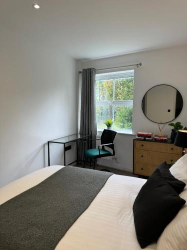 1 dormitorio con cama, espejo y silla en Coocos Den, en Hillingdon