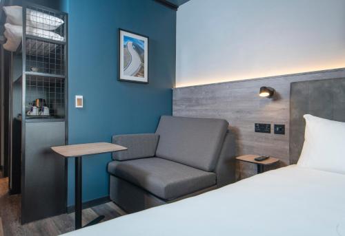 a bedroom with a bed and a chair and a table at ibis Styles London Gatwick Airport in Crawley
