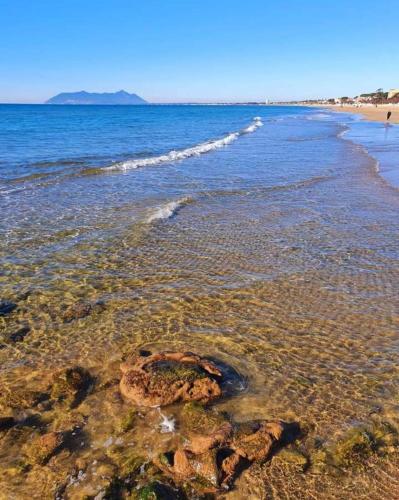 a beach with rocks and the ocean with waves at Oniria Suite - 100 mt dal mare in Terracina