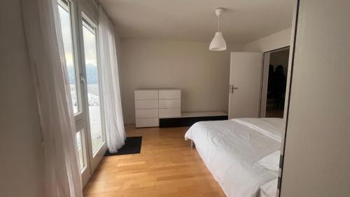 una camera con un letto bianco e una grande finestra di Swiss Paradise Weggis a Weggis