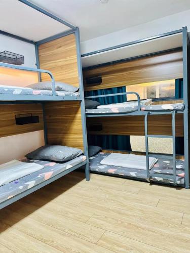 a room with three bunk beds in a room at 安家青年寓舍深圳北站店Anjia Youth Hostel Shenzhen Railway North Branch in Lung Wa