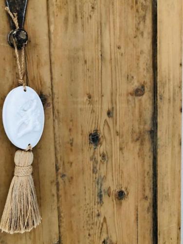 a wall with a white plate and a tassel at OSPITE al N 5 home in Mondovì