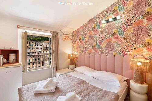 a bedroom with a bed and a floral wall at Il Mare Sotto in Riomaggiore