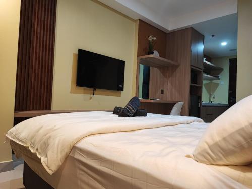 a bedroom with a large bed with a flat screen tv at Serene Studio Pollux Batam Center - High Floor Sea View in Batam Center