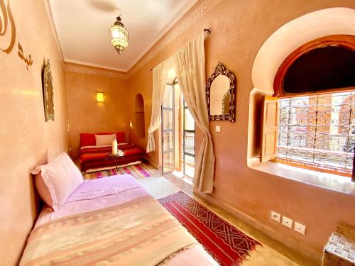 1 dormitorio con cama, ventana y sofá en Riad Prada, en Marrakech